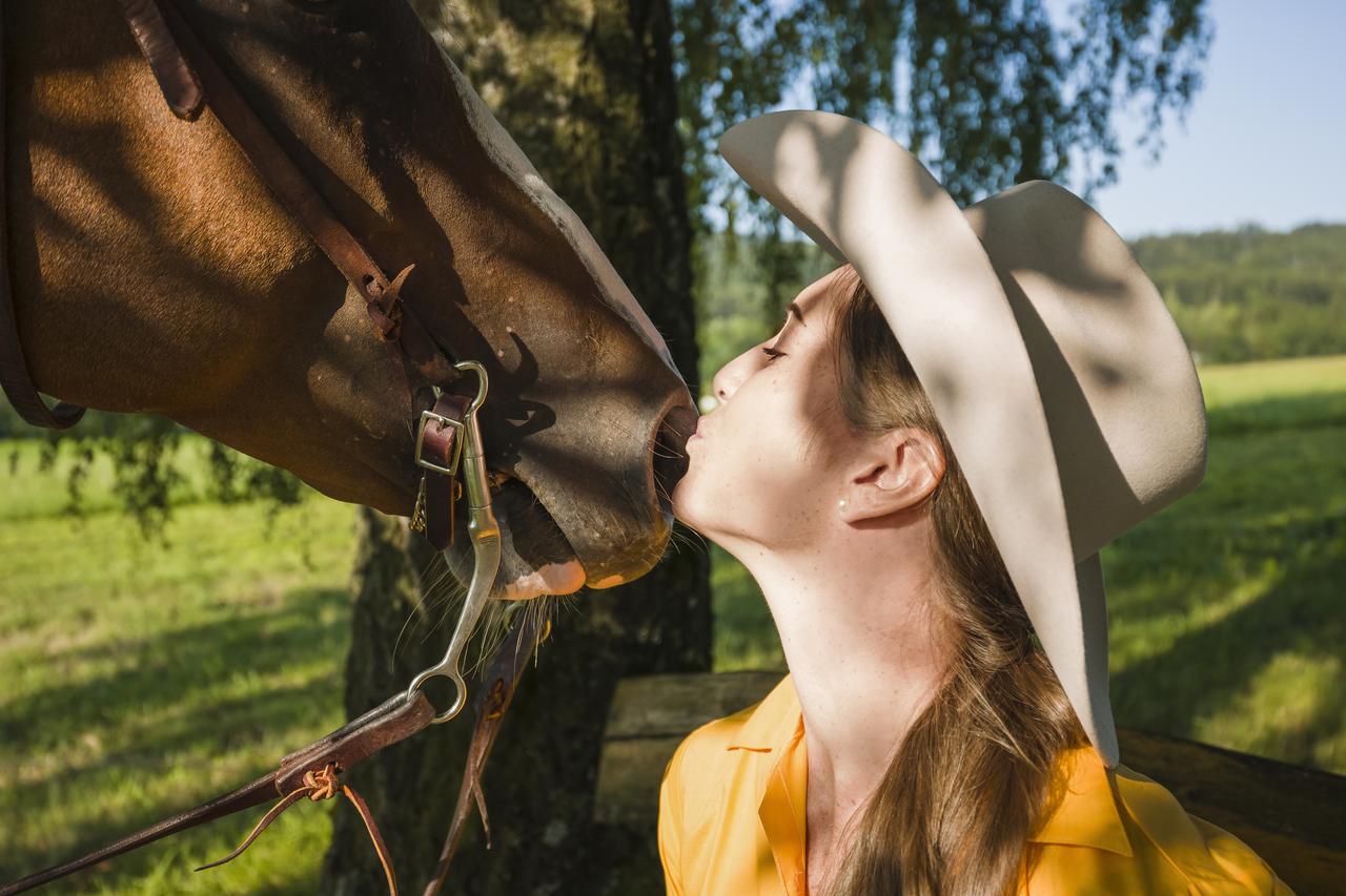 Reiterin küsst Nüstern von Pferd