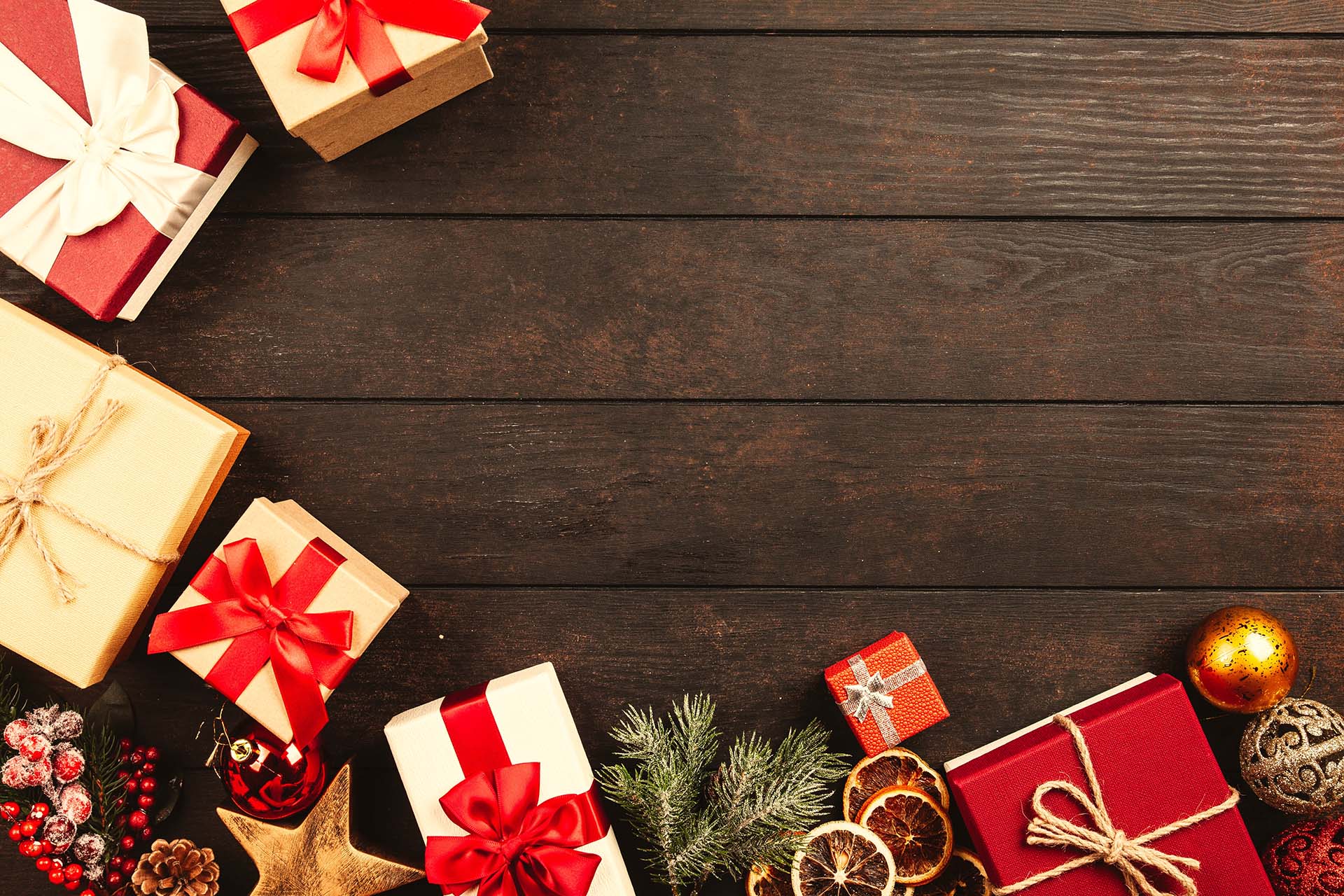 Holztisch mit weihnachtlicher Deko in rot/gold und Geschenken